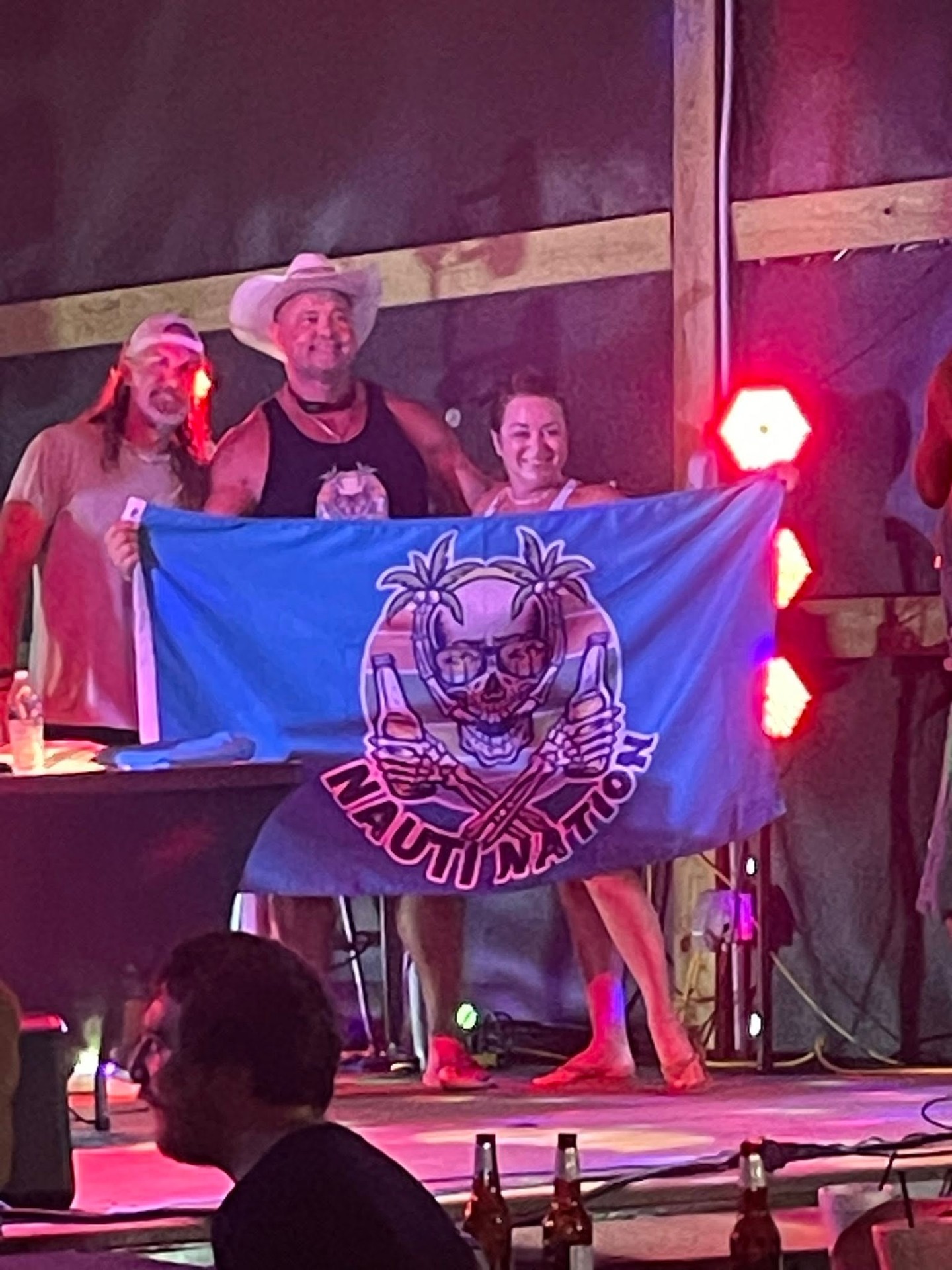 Attendees holding the Nauti Nation flag on stage
